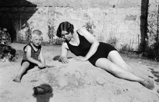 Marie Kousnetzoff en maillot de bain sombre allongée à côté de son fils Dimitri