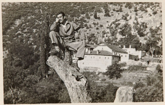 Portrait photographique noir et blanc d'un homme assis sur un tronc d'arbre